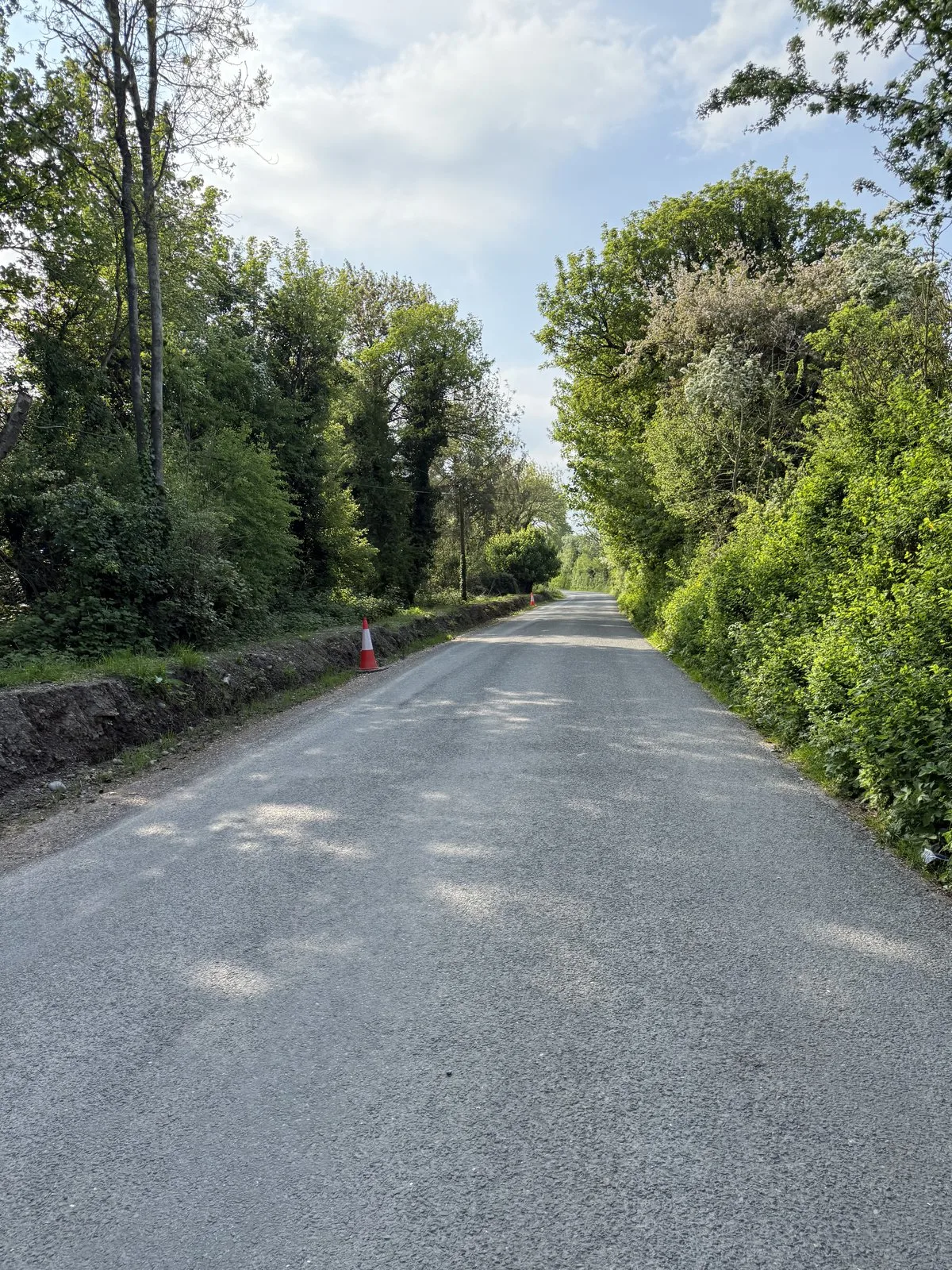 The long open earth bank along the approach road to the bridge.